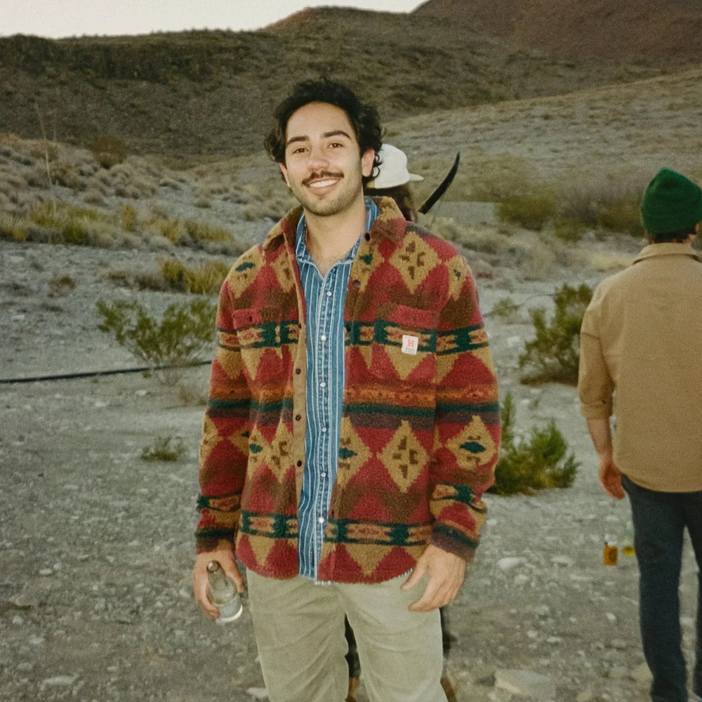 Man wearing a patterned jacket in a desert-like setting