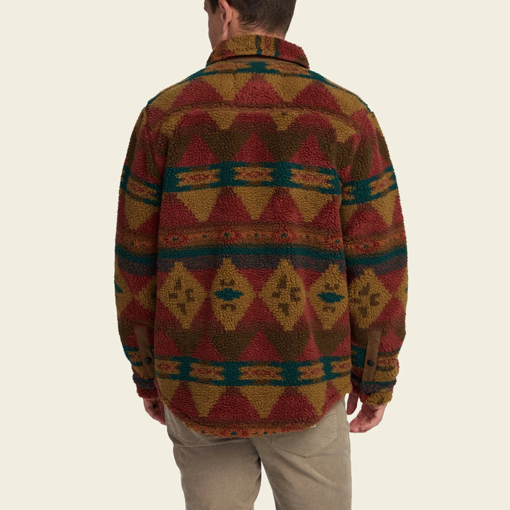 Person wearing a patterned jacket on a beige background