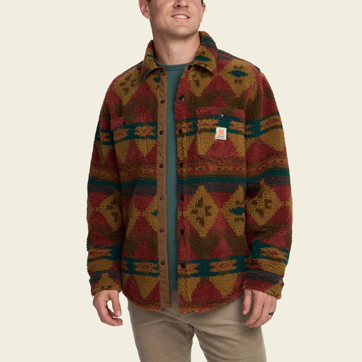 Person wearing a patterned jacket on a beige background