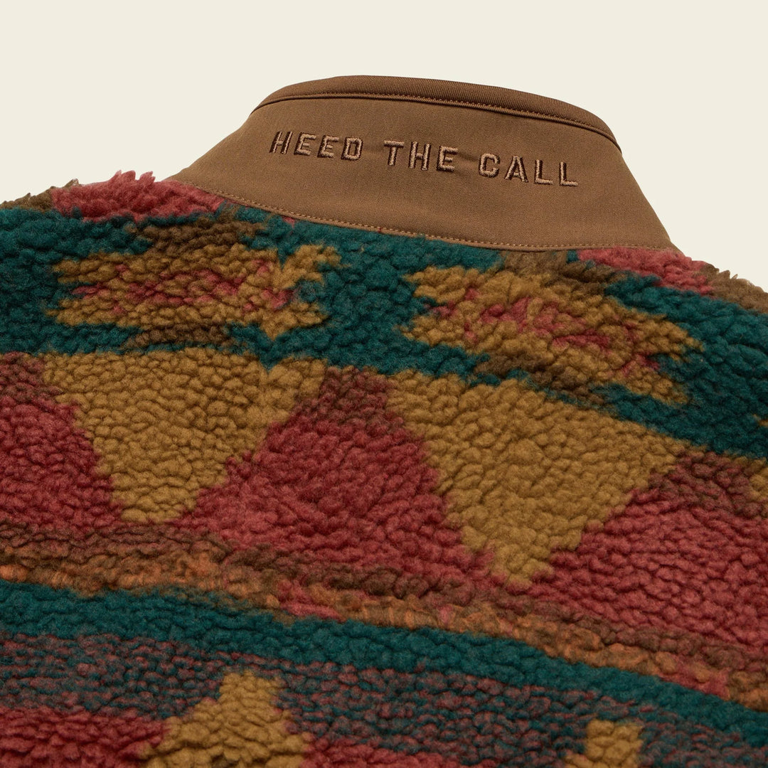 Colorful patterned jacket with 'HEED THE CALL' text on collar against a beige background