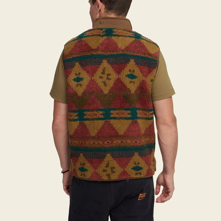 Person wearing a patterned vest with a plain background