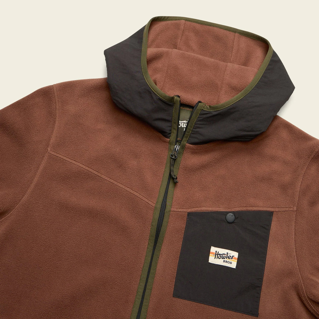 Brown fleece jacket with black accents and a visible brand logo on a beige background