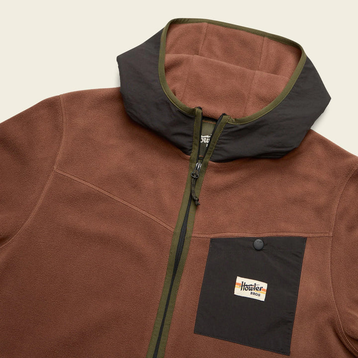 Brown fleece jacket with black accents and a visible brand logo on a beige background
