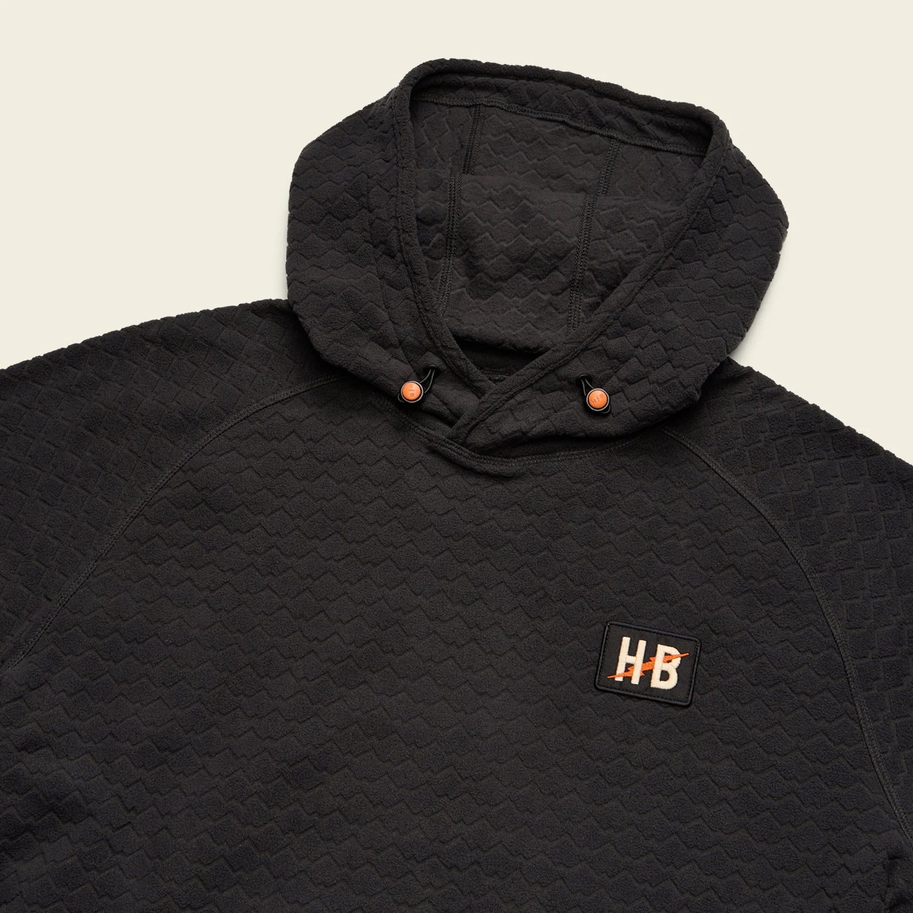 Black quilted jacket with a brand logo on a beige background