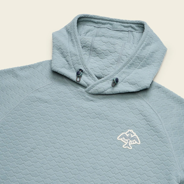Light blue quilted jacket with a logo on a beige background