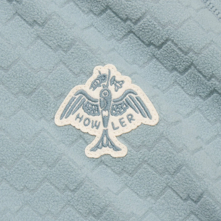 Embroidered logo on a textured blue fabric background