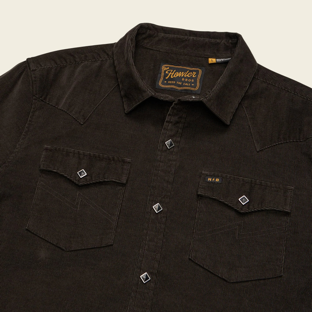 Dark brown shirt with a brand label on a beige background