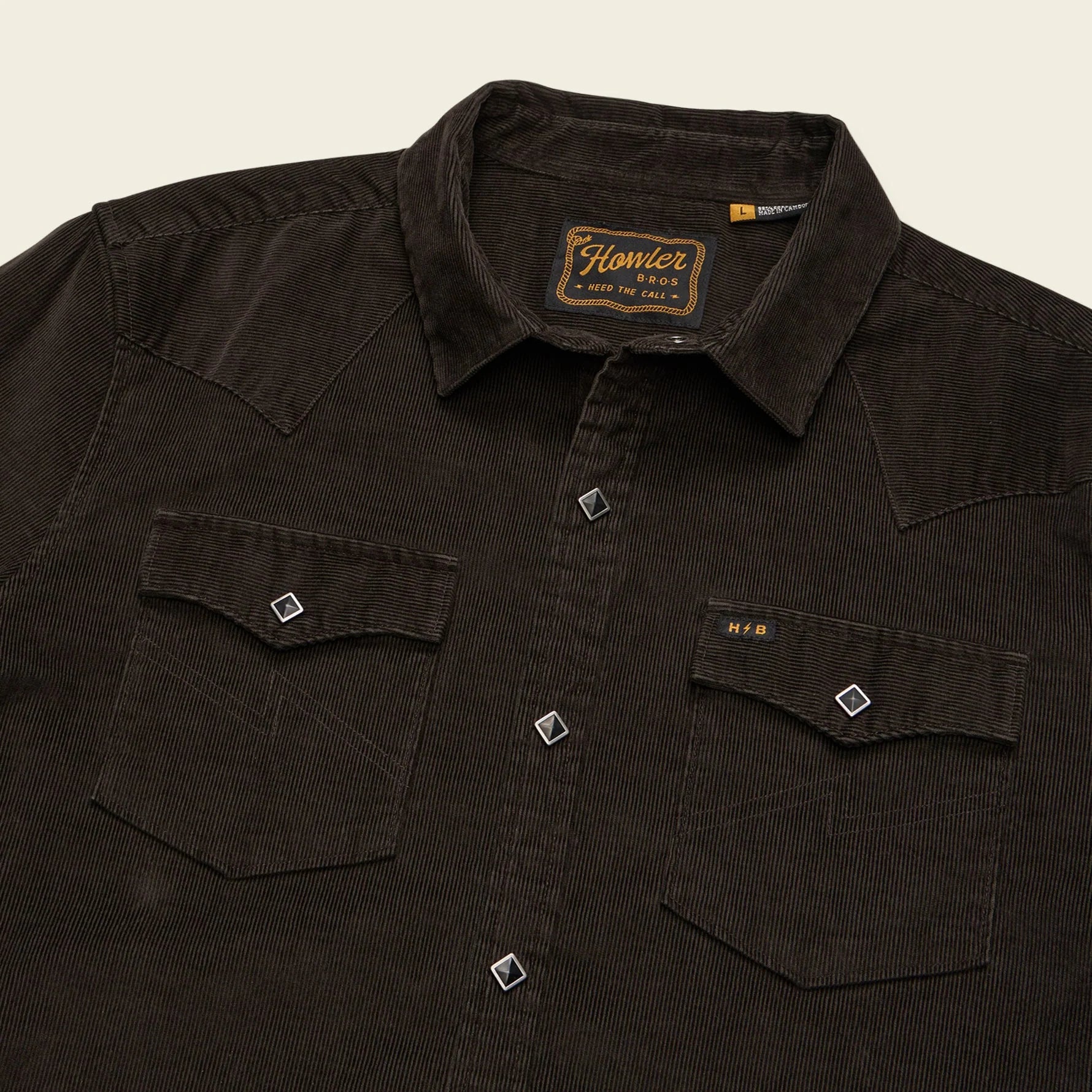 Dark brown shirt with a brand label on a beige background