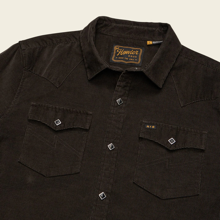 Dark brown shirt with a brand label on a beige background