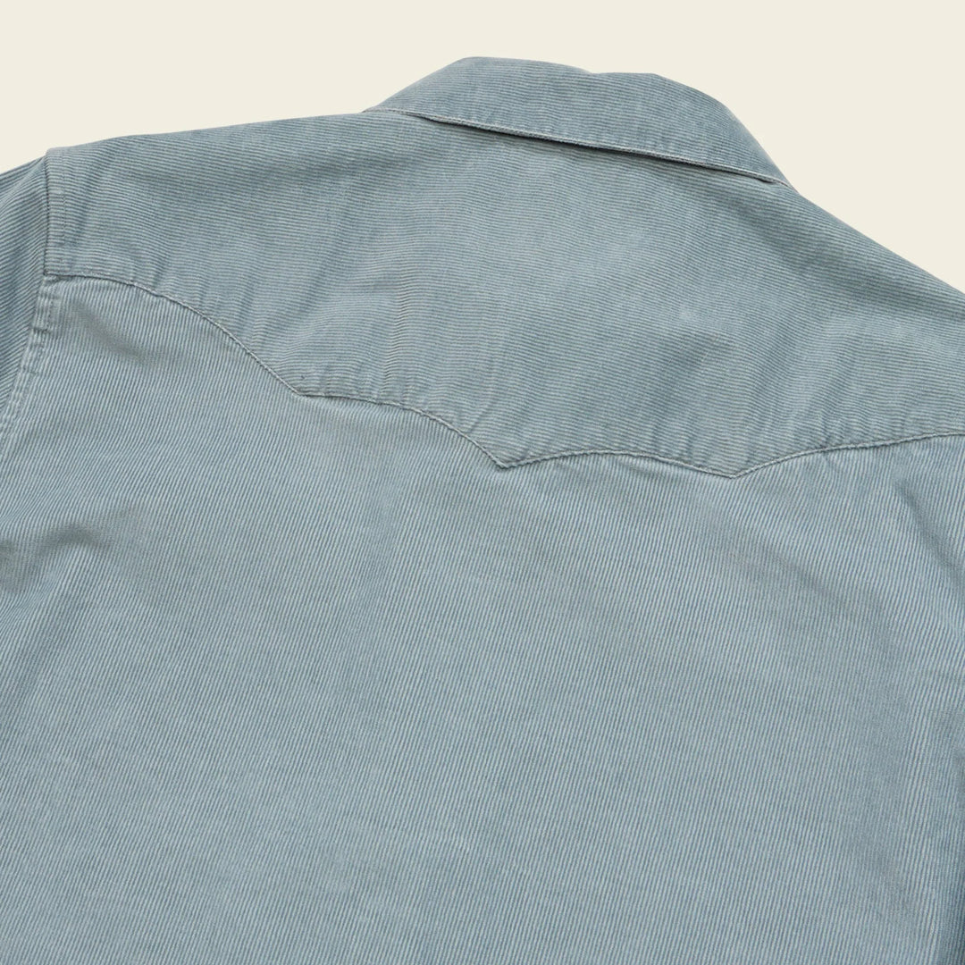 Light blue denim shirt on a beige background