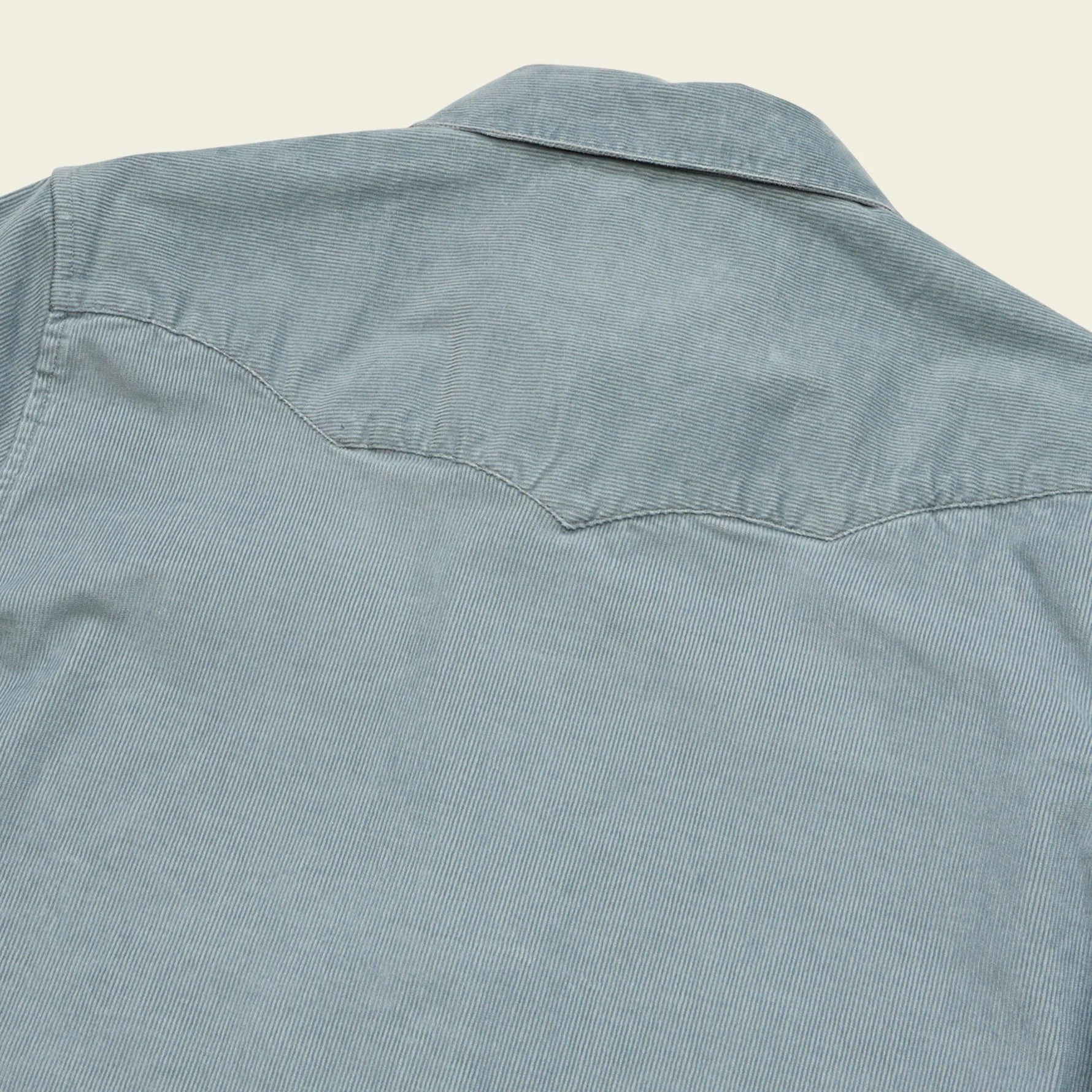 Light blue denim shirt on a beige background