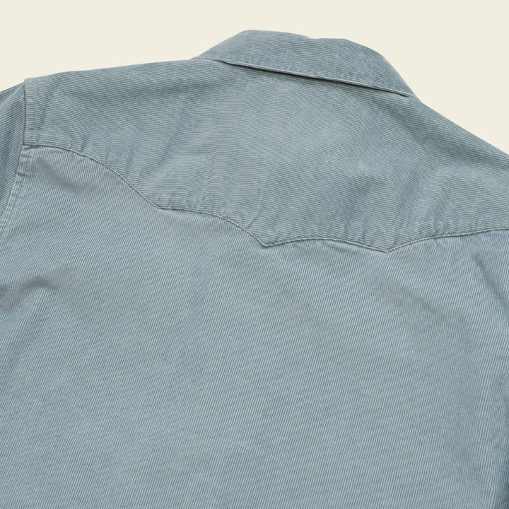 Light blue denim shirt on a beige background