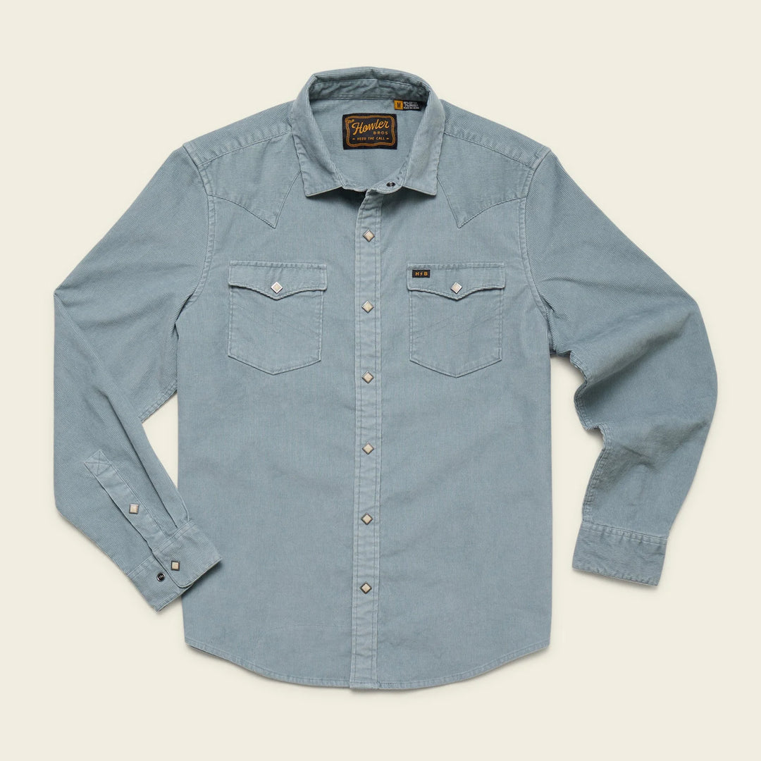 Light blue denim shirt with a brand label on a beige background