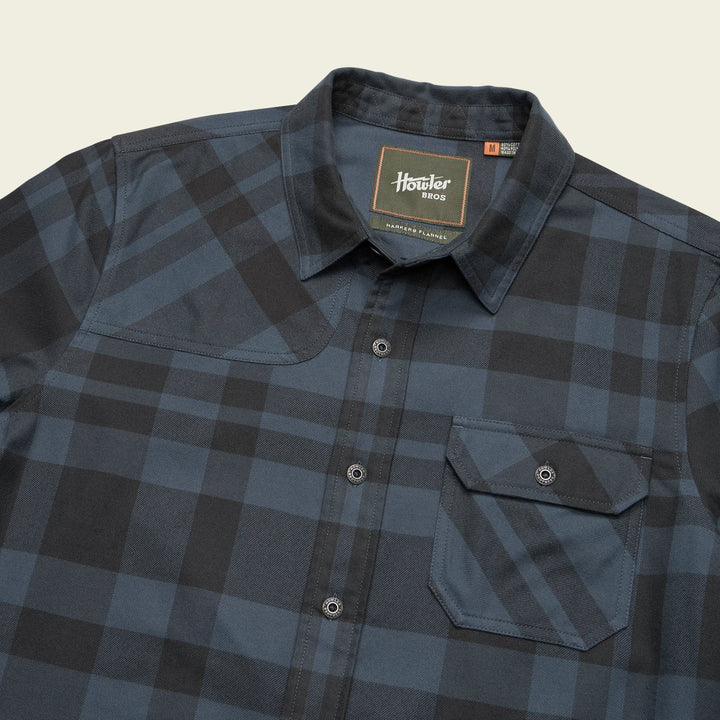 Plaid shirt with a brand label on a neutral background