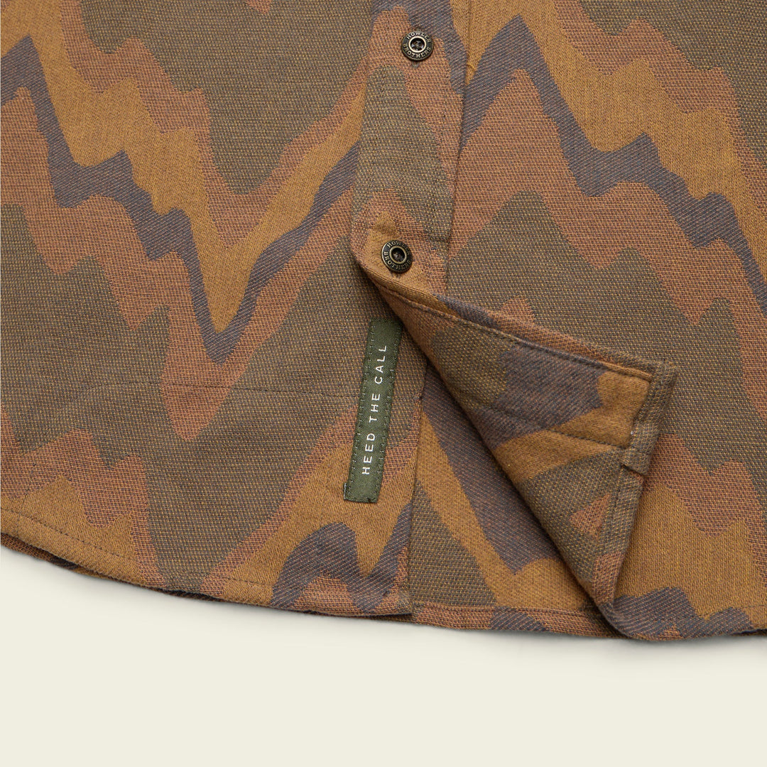 Camouflage-patterned fabric with a brand label on a light background