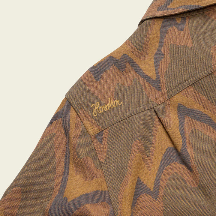 Camouflage-patterned shirt with a brand logo on a beige background