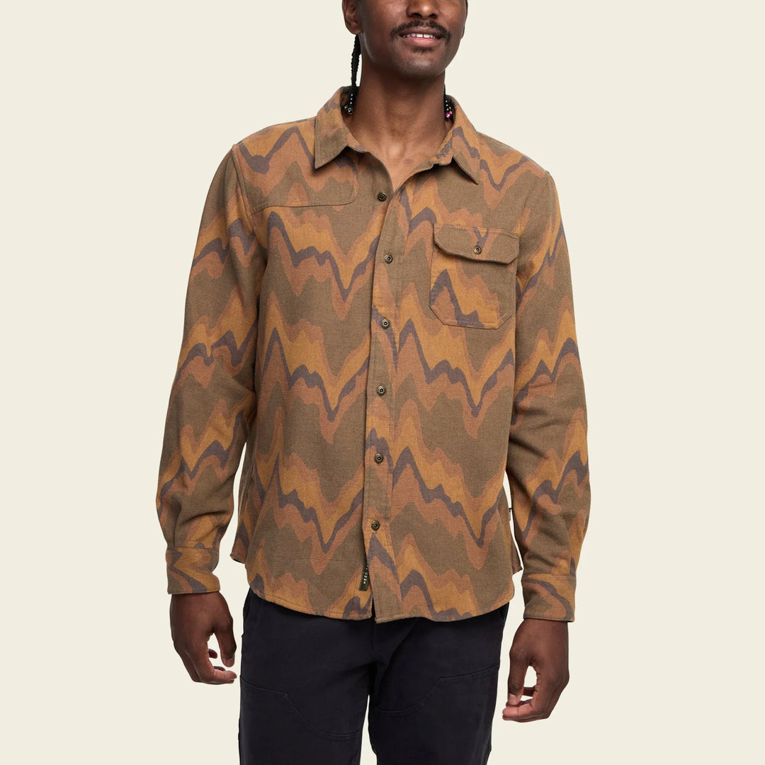Man wearing a brown and orange patterned shirt on a beige background