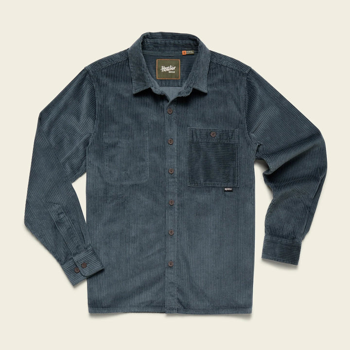 Blue corduroy shirt with button details on a beige background