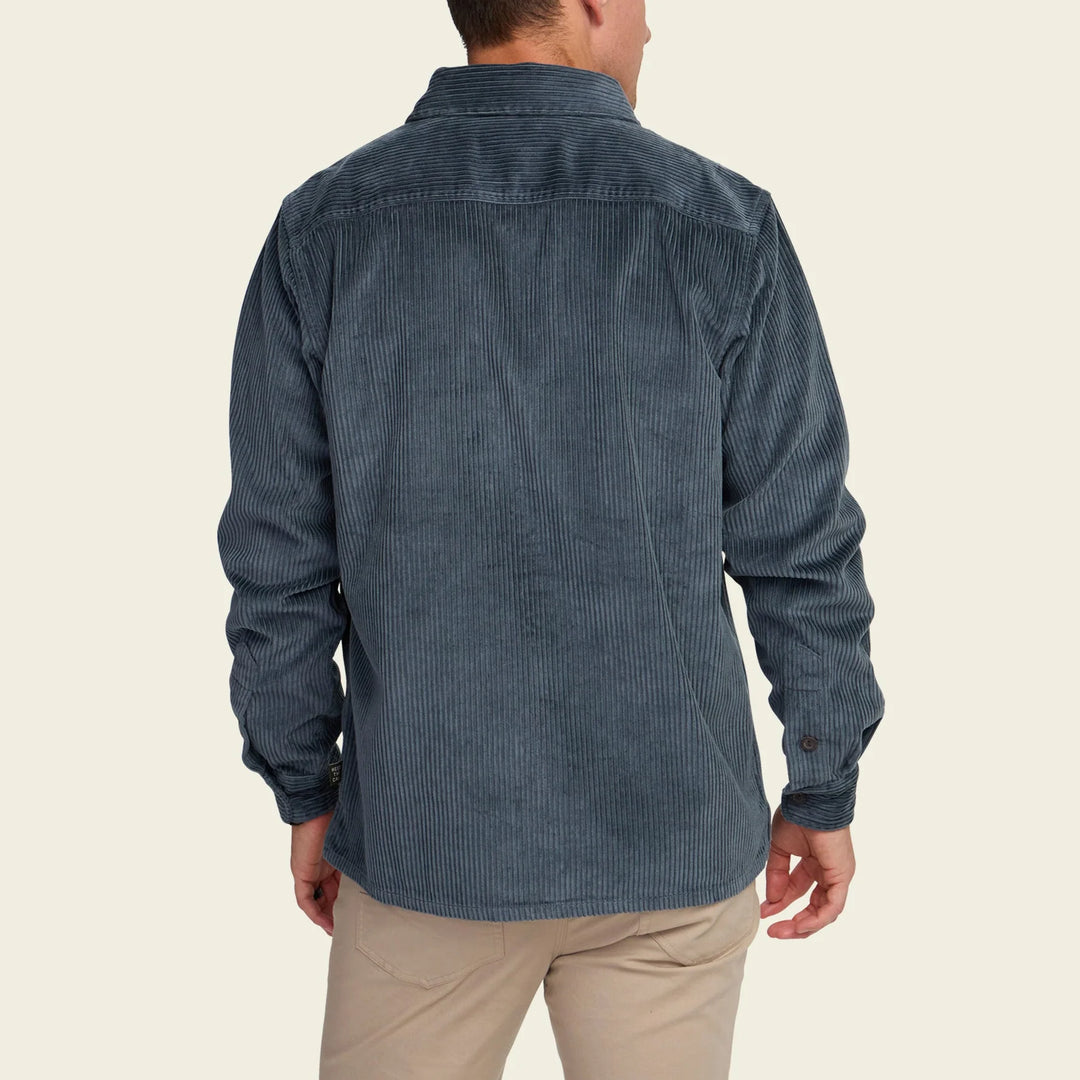 Man wearing a blue corduroy shirt on a beige background