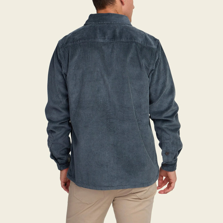 Man wearing a blue corduroy shirt on a beige background