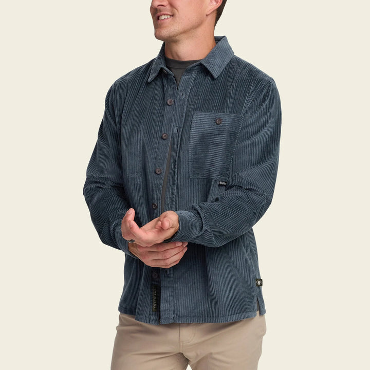 Man wearing a blue corduroy shirt on a beige background
