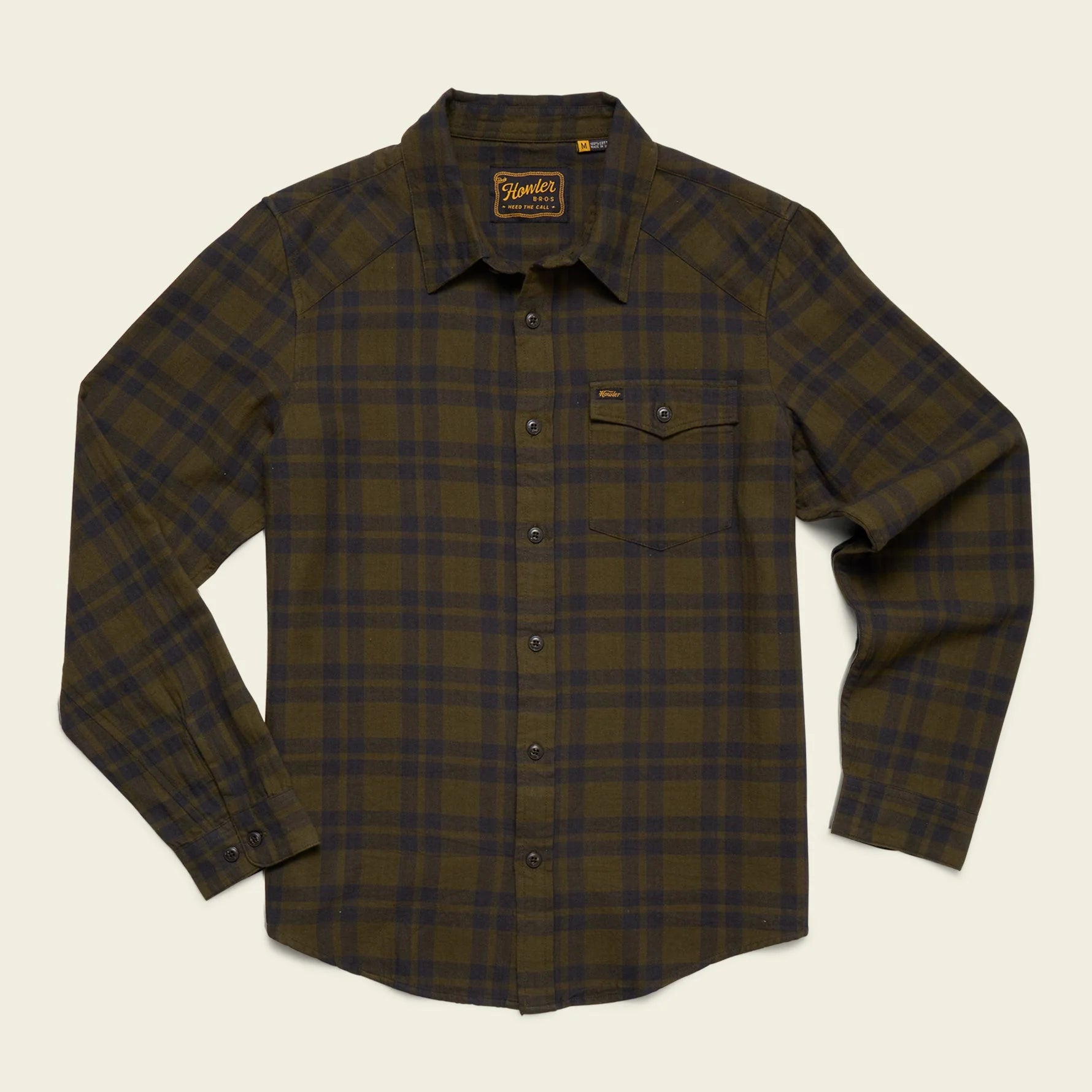 Howler Brothers plaid shirt with a brand label on a beige background