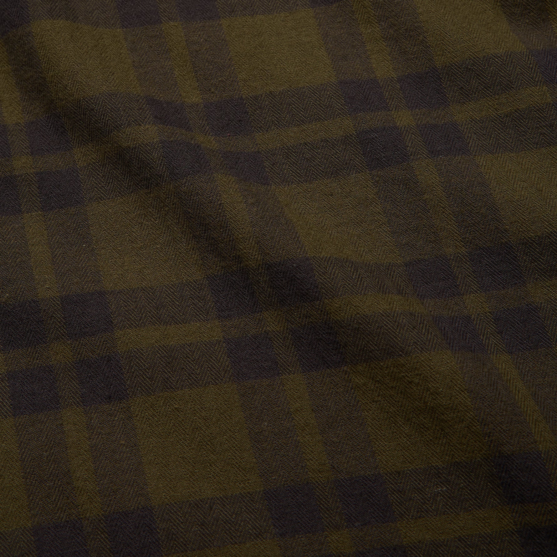 Close-up of a brown and black checkered fabric of the Howler Brothers plaid shirt