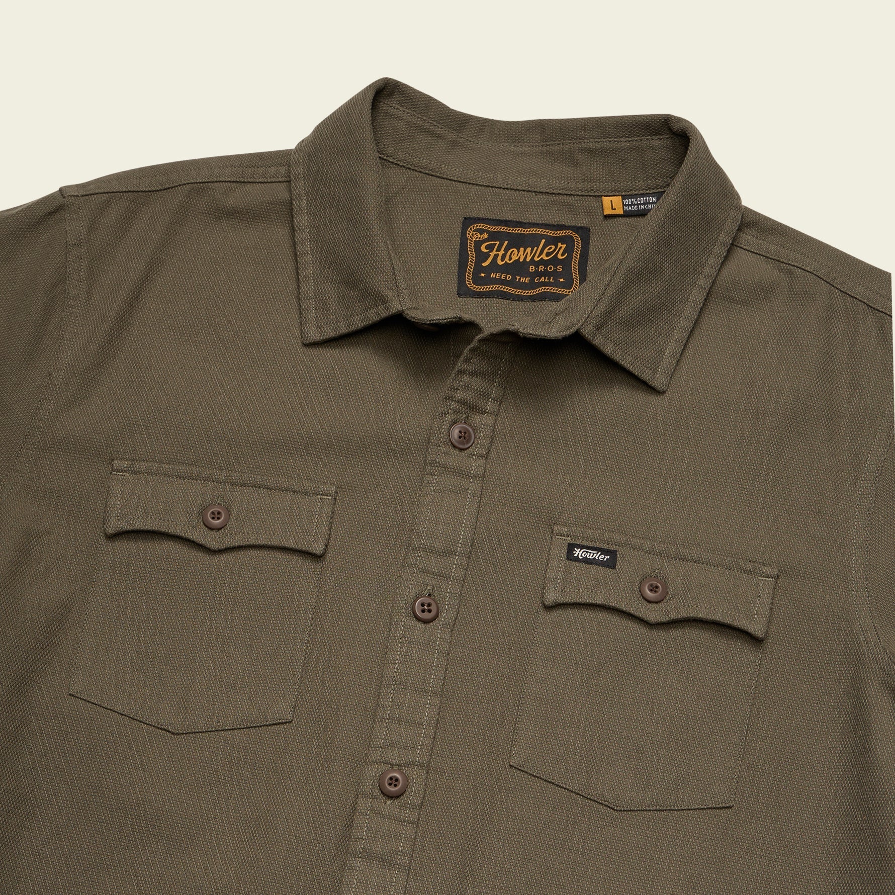 Brown shirt with a visible brand logo on a beige background