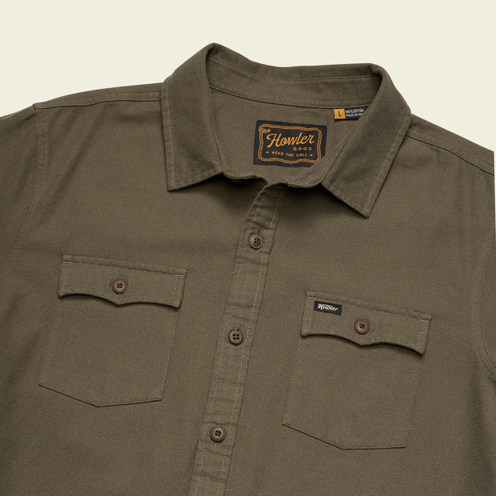 Brown shirt with a visible brand logo on a beige background