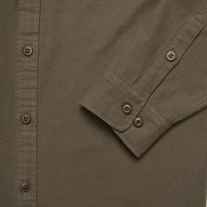 Close-up of a green shirt with button details
