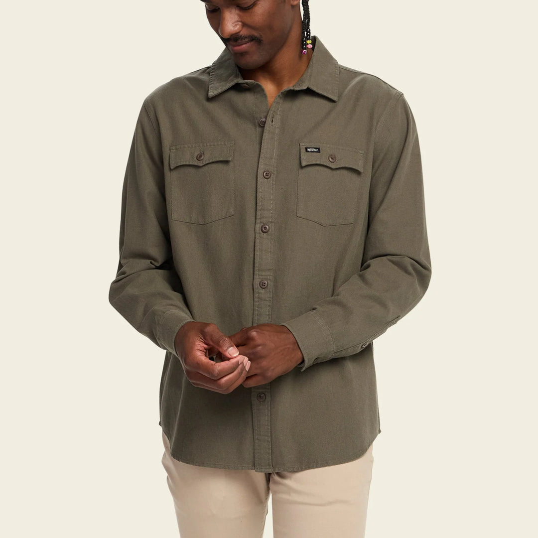 Person wearing a green shirt with a beige background