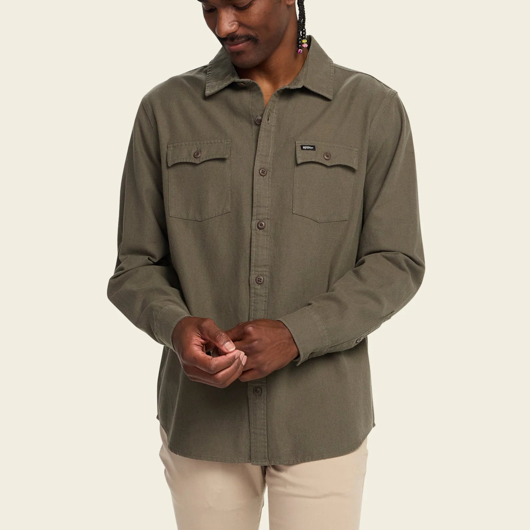Person wearing a green shirt with a beige background