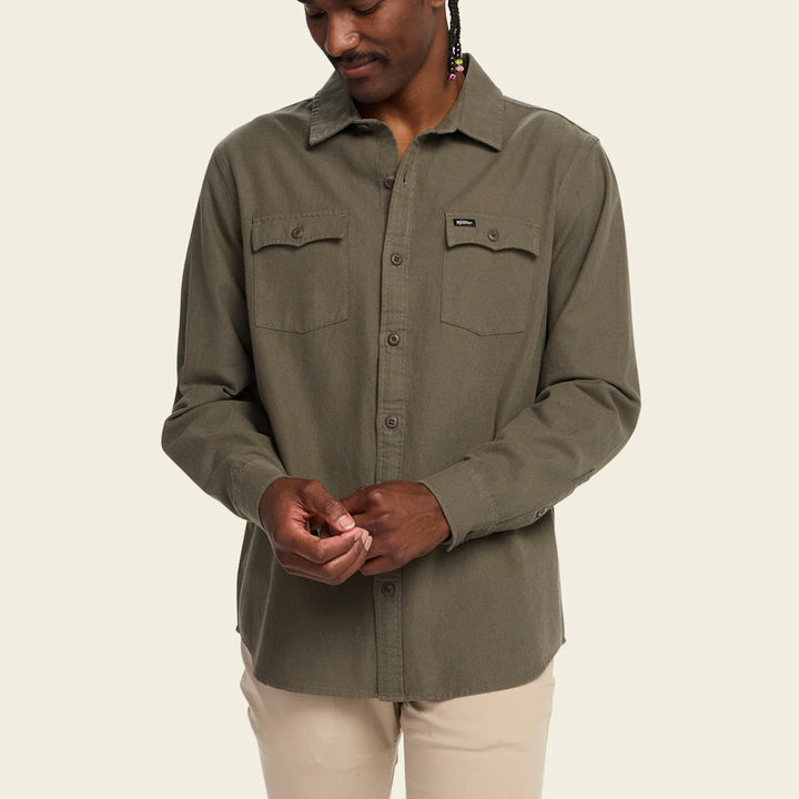 Person wearing a green shirt with a beige background