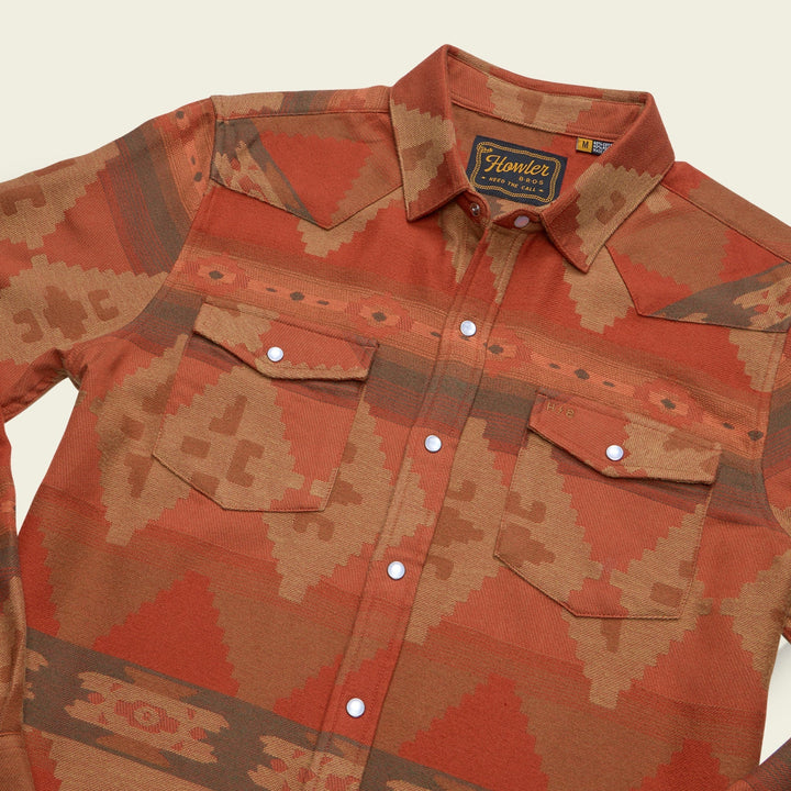 Orange and brown patterned shirt with a brand label on a beige background