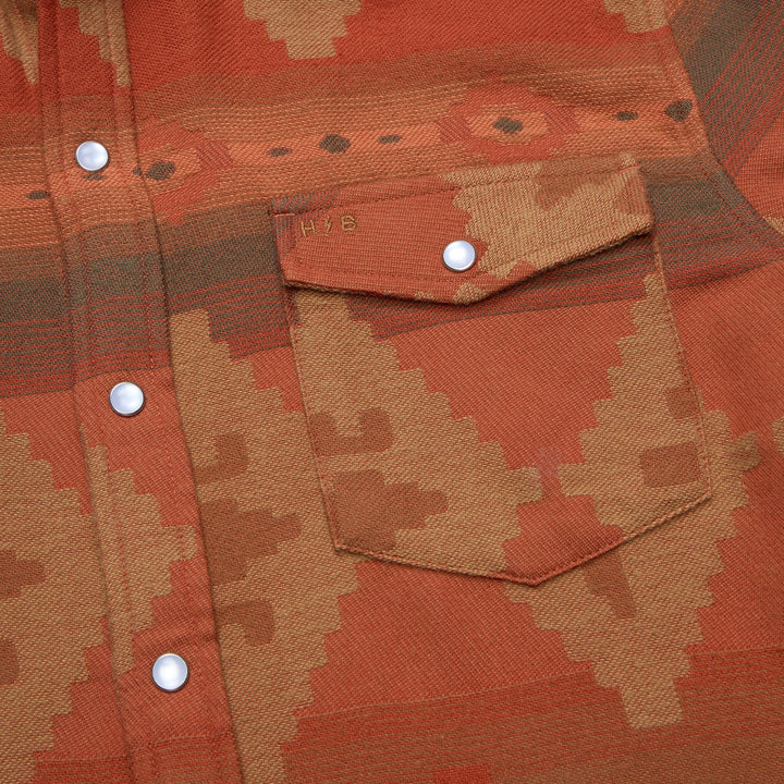 Close-up of a patterned shirt with buttons and a pocket.