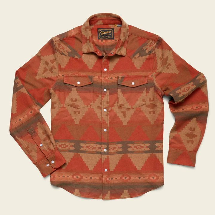 Red and brown patterned shirt with brand label on a beige background