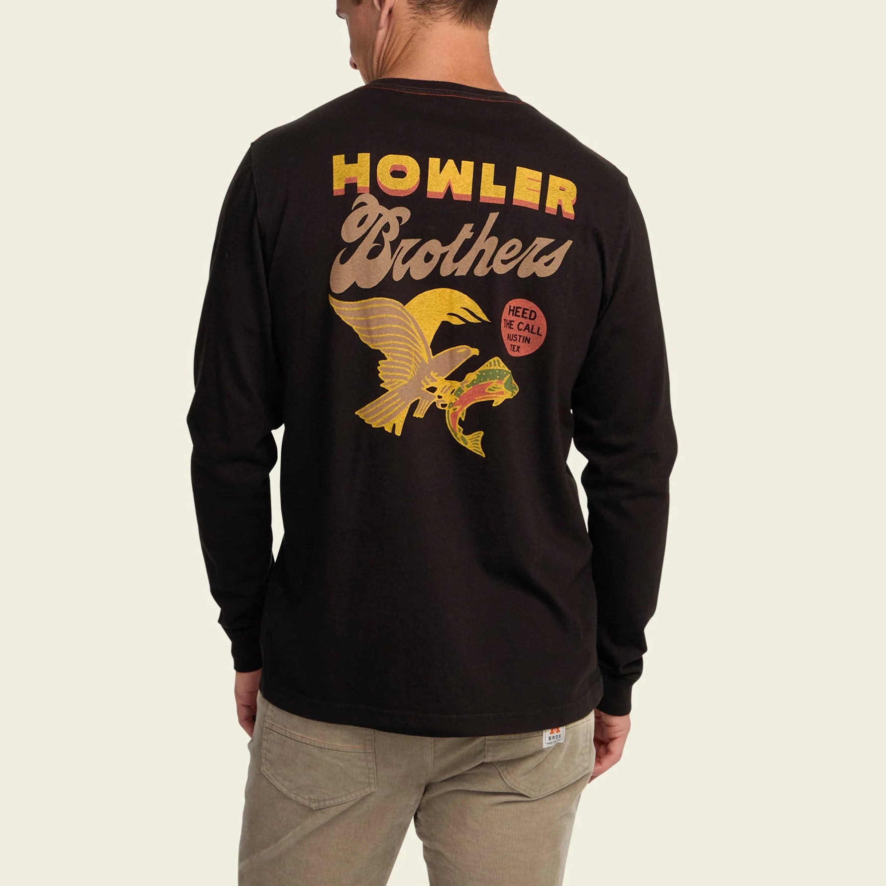 Black long-sleeve shirt with 'Howler Brothers' logo on the back, worn by a person.