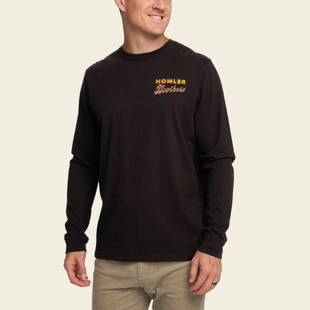 Man wearing a black long-sleeve shirt with 'Howler Brothers' logo on a beige background