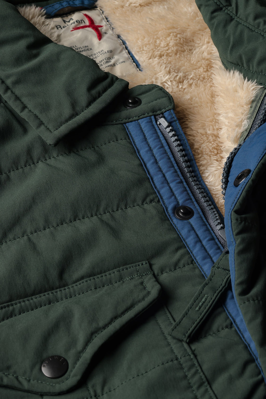 Close-up of a green jacket with blue lining and fur collar.
