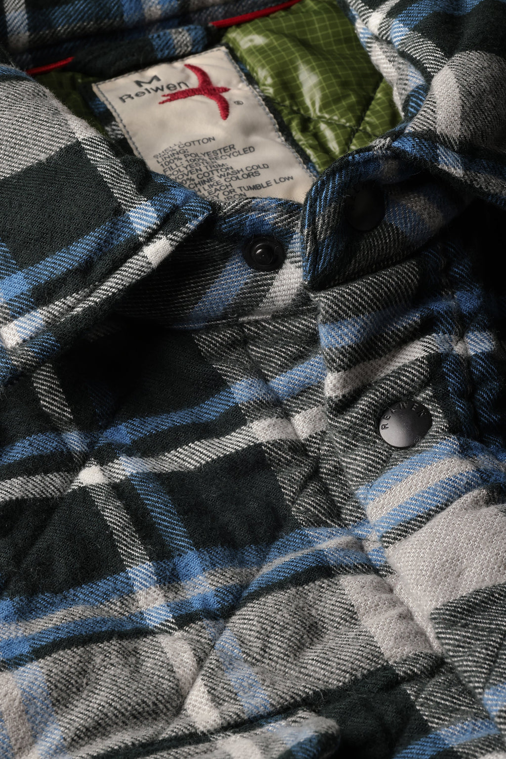 Close-up of a plaid flannel shirt jacket with a visible neck label reading 'M. Newon'.