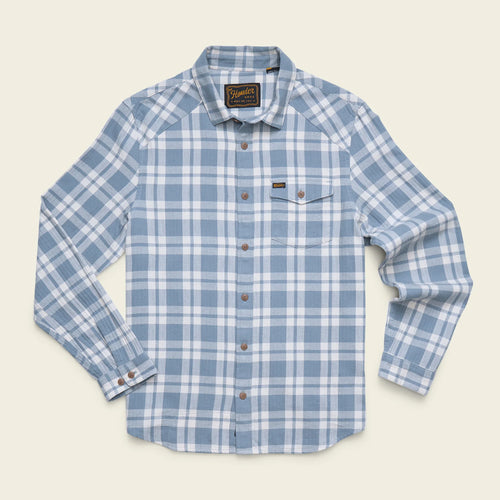 A light blue and white plaid long-sleeve button-up shirt with a chest pocket, laid flat on a light beige background. The brand label on the inner collar reads 'Rip Curl'.