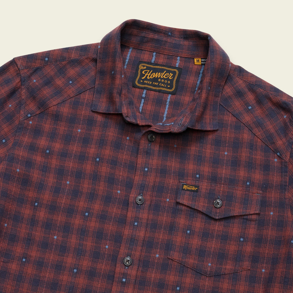 A close-up of a Hunter Redwood plaid button-down shirt in red and navy blue, featuring a small chest pocket and a Hunter brand label.