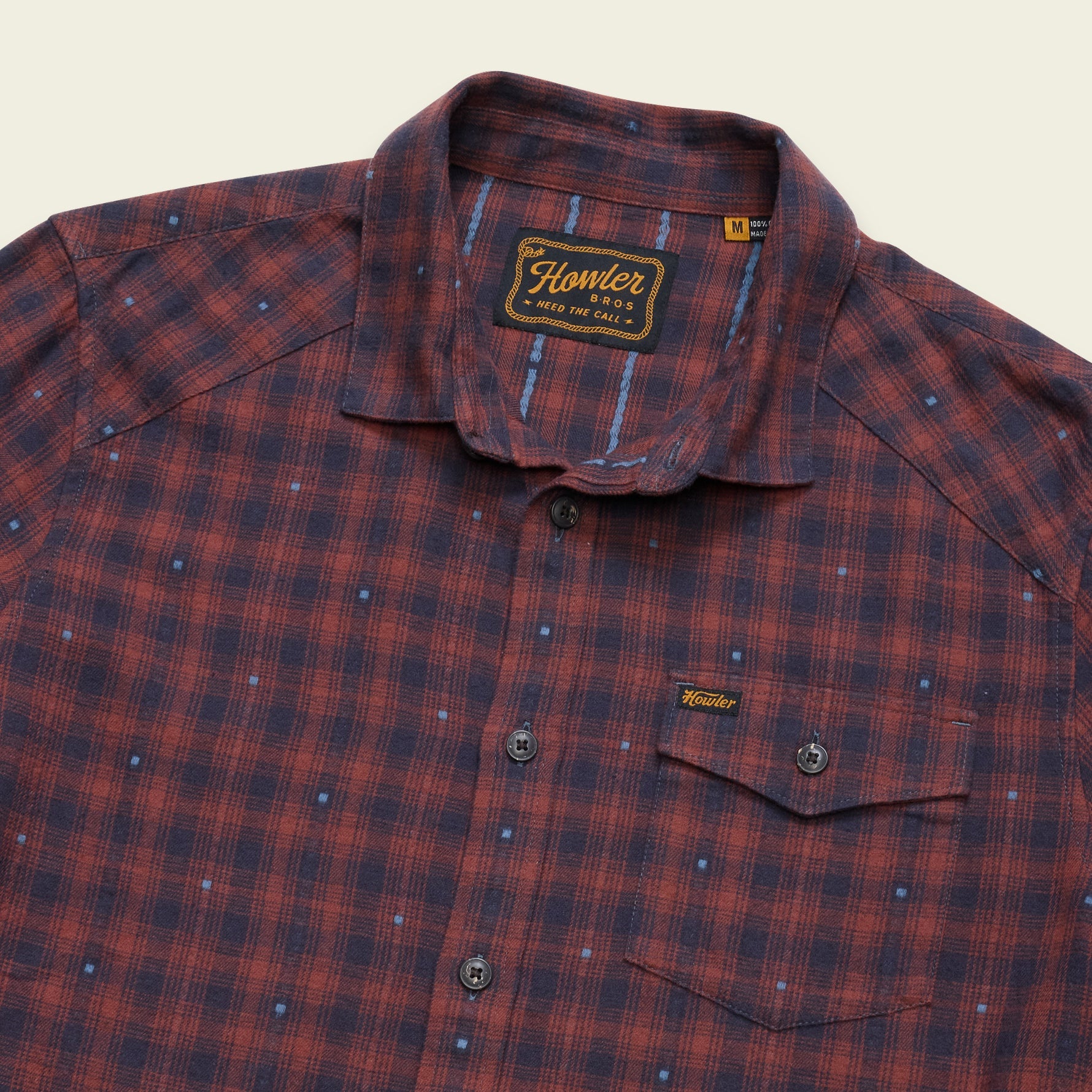 A close-up of a Hunter Redwood plaid button-down shirt in red and navy blue, featuring a small chest pocket and a Hunter brand label.