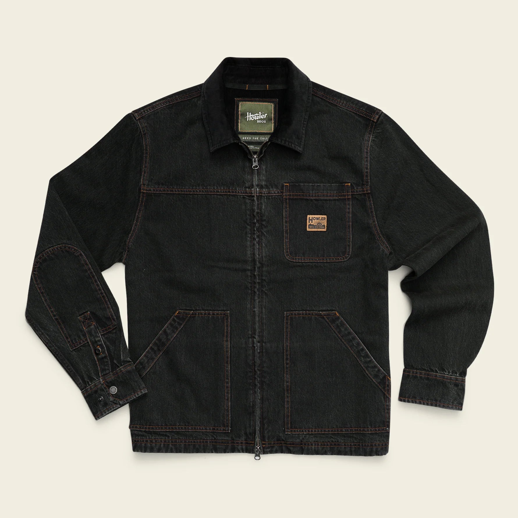 A dark washed denim Carhartt jacket with a front zipper, buttoned cuffs, and a brown Carhartt logo patch on the chest pocket, laid flat against a light beige background.