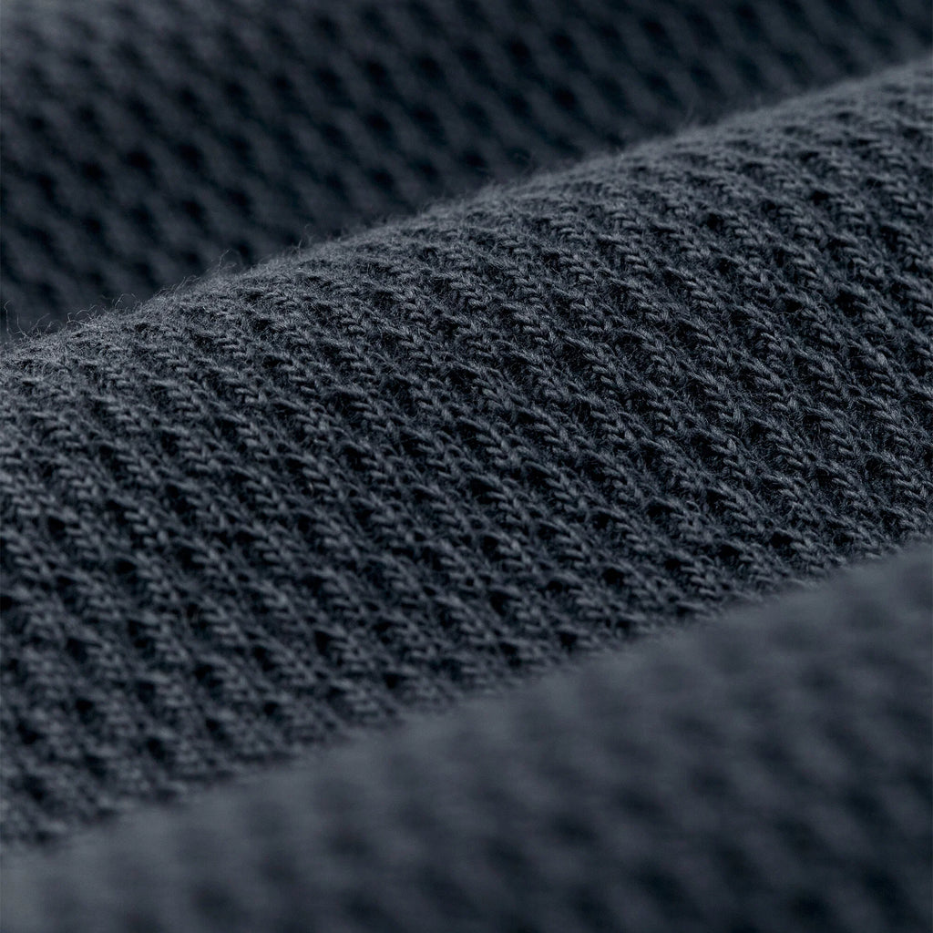 Close-up of a dark charcoal gray knit fabric texture with a fine ribbed pattern.