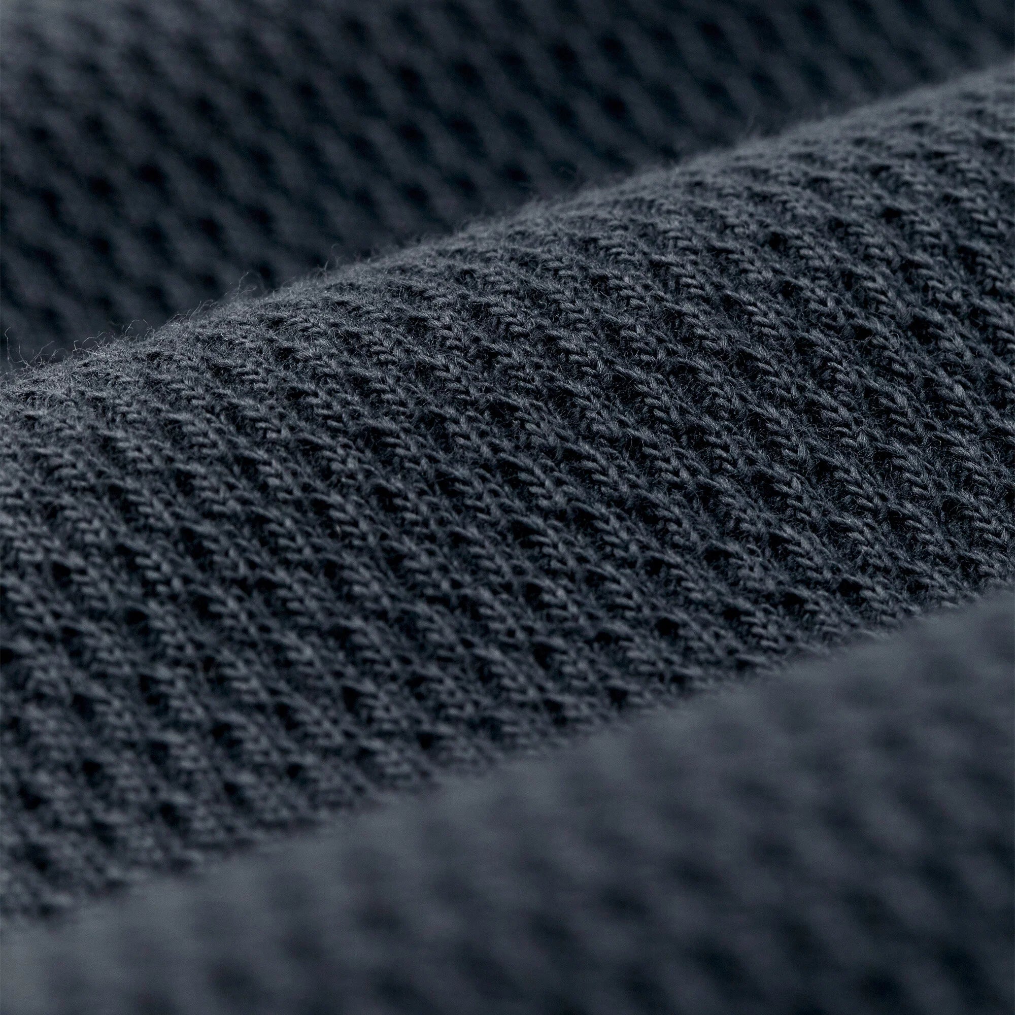 Close-up of a dark charcoal gray knit fabric texture with a fine ribbed pattern.