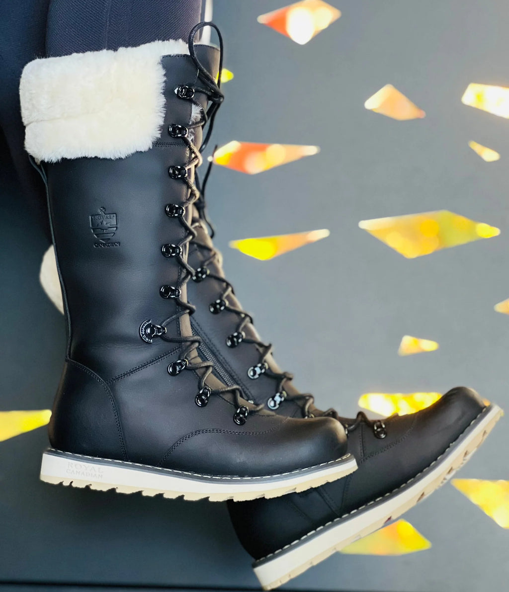 Black winter boots with white fur lining on a dark background