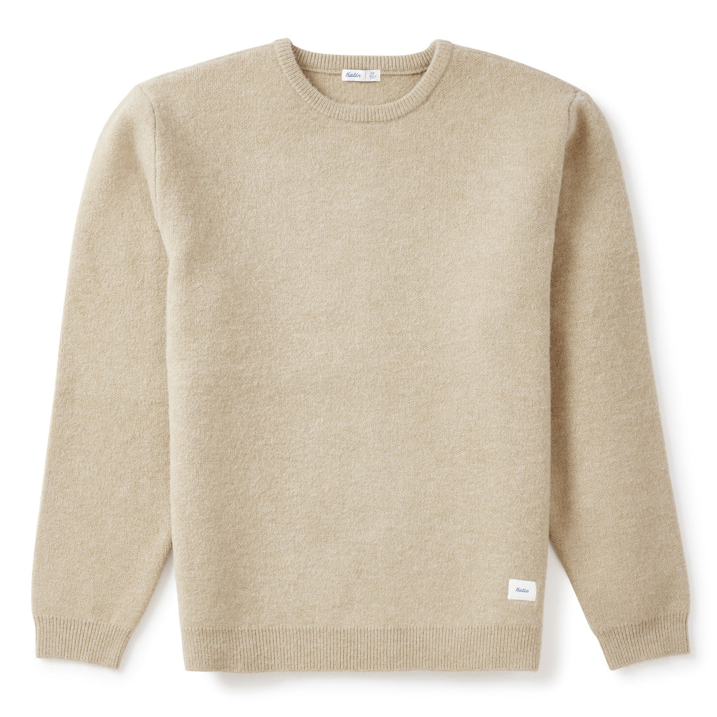 A light beige crewneck sweater with long sleeves, laid flat against a clean white background.