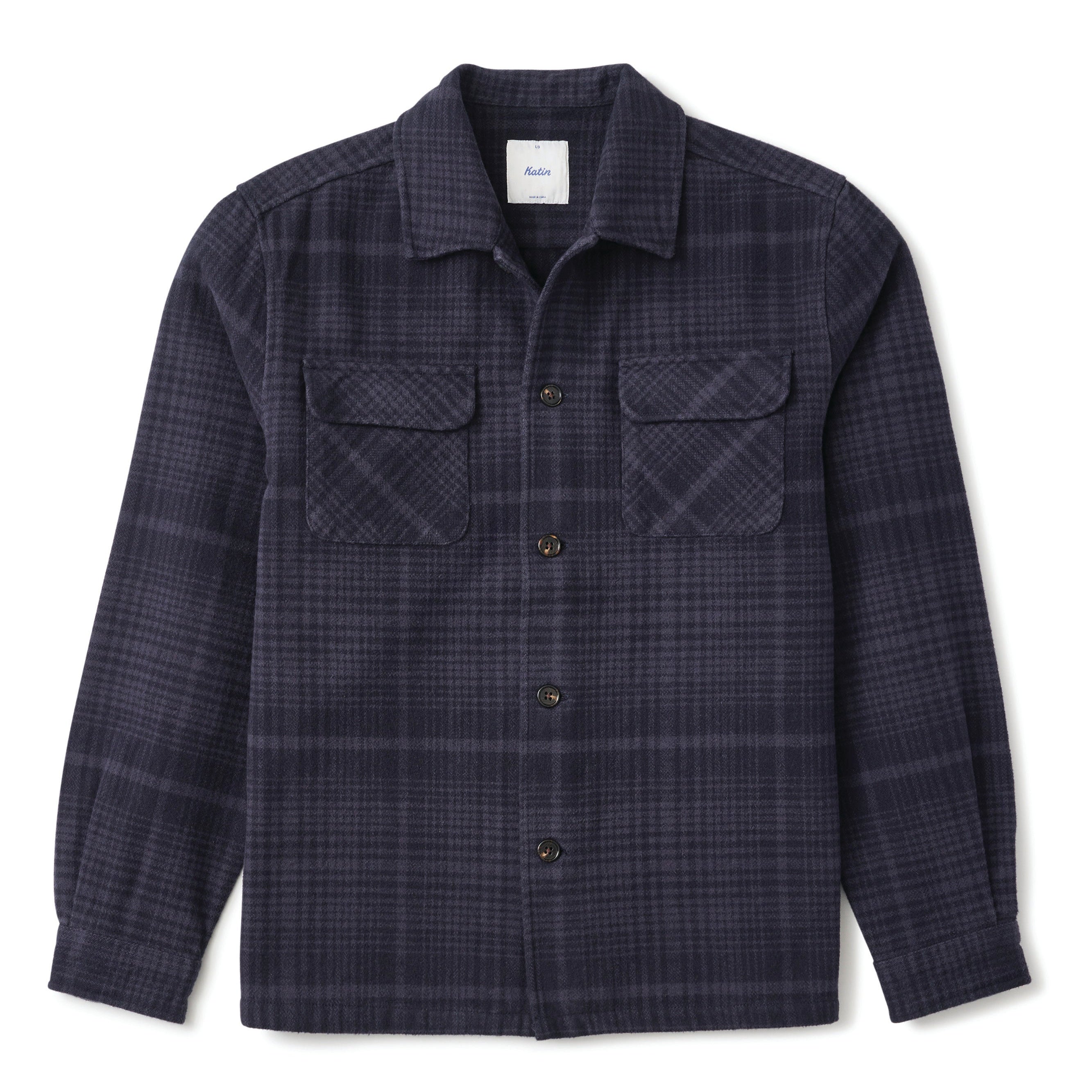 A dark navy plaid button-up shirt jacket with two chest flap pockets, displayed flat against a white background.