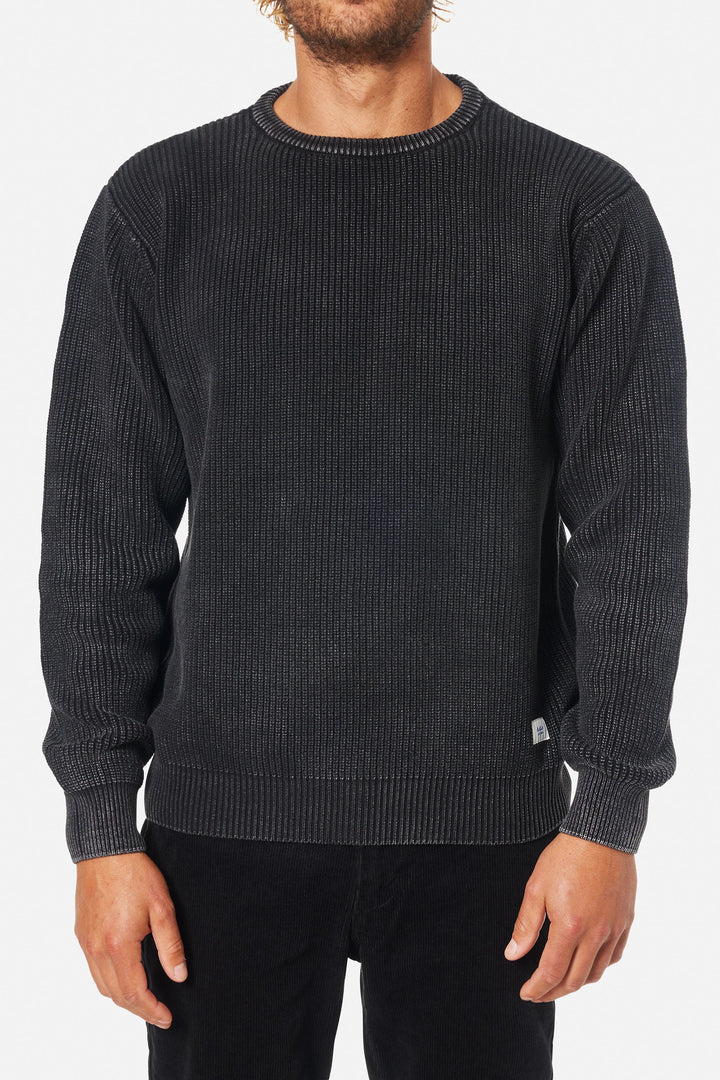 Man wearing a dark gray ribbed sweater on a white background